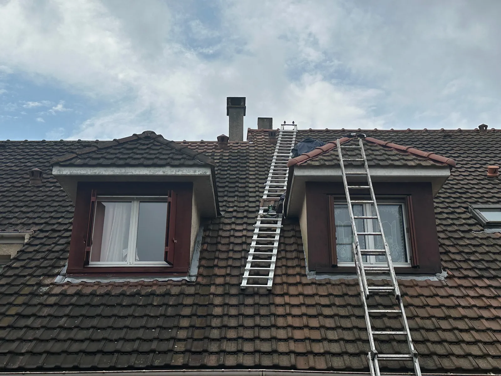 Échelles montées jusqu'à la souche de cheminée d'un pavillon