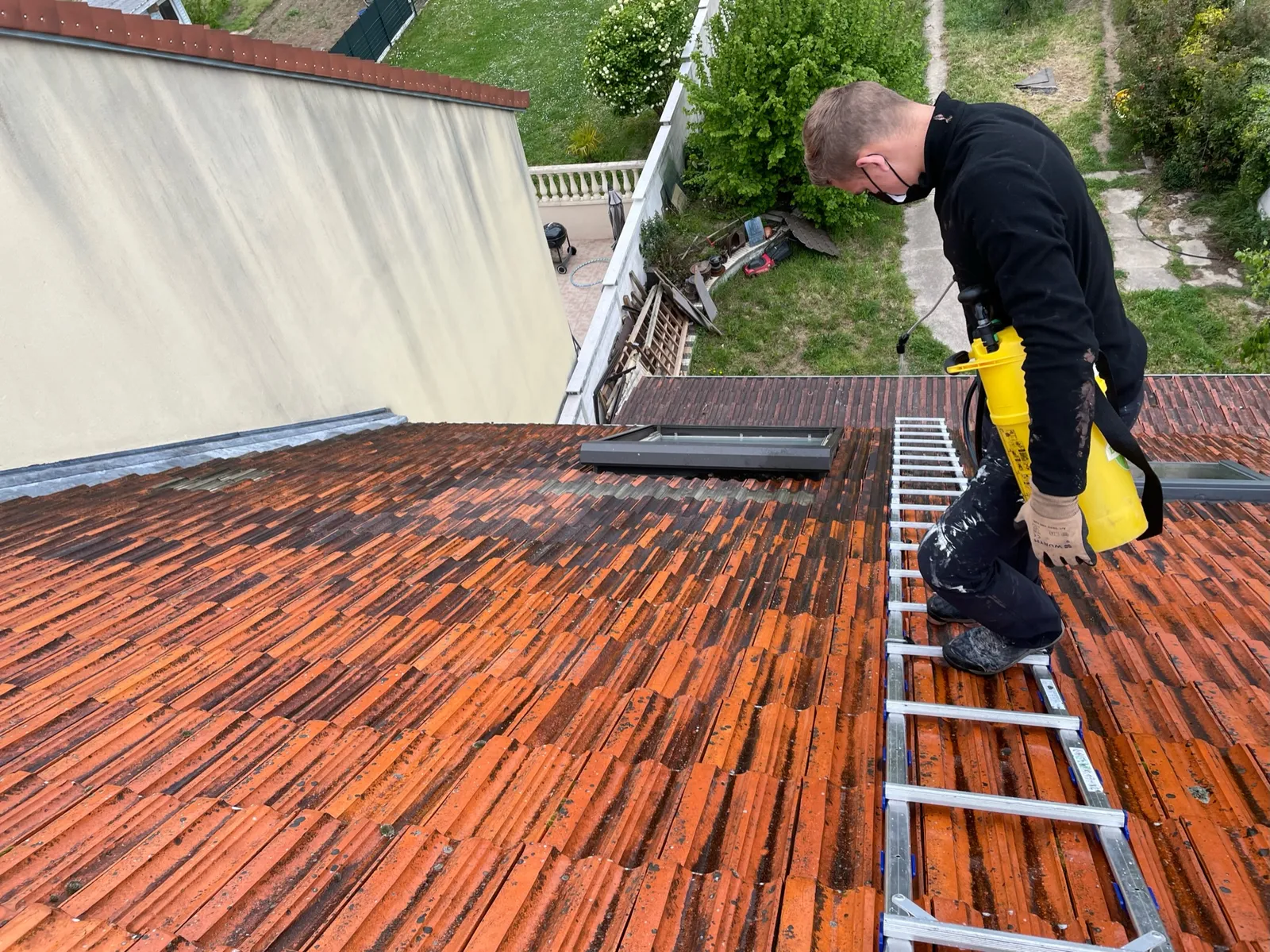 Toiture à moitié démoussée par Adnot Couverture dans les Yvelines
