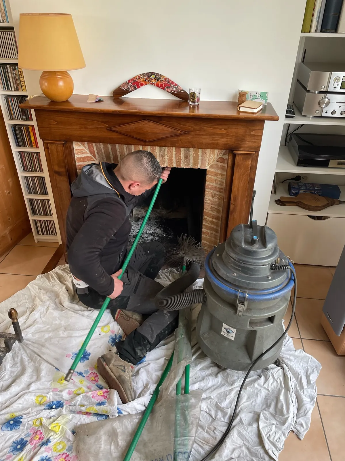 Ramonage d'un foyer ouvert avec aspirateur à suie et sol bâché par Adnot Couverture